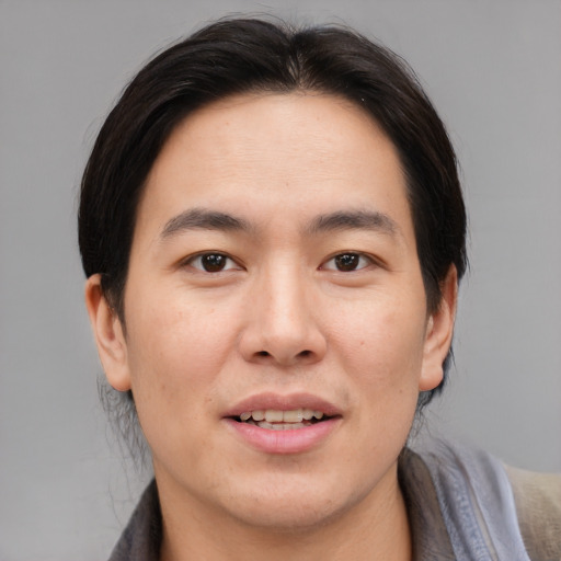 Joyful asian young-adult male with medium  brown hair and brown eyes