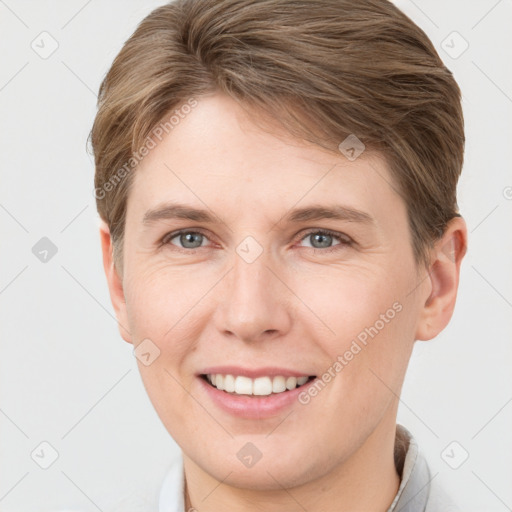 Joyful white young-adult female with short  brown hair and grey eyes