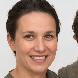 Joyful white adult female with medium  brown hair and grey eyes