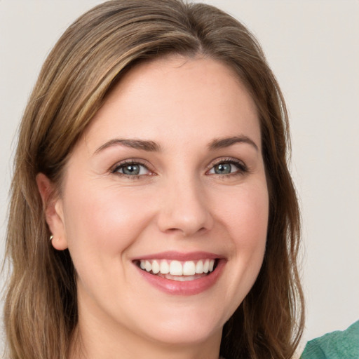 Joyful white young-adult female with medium  brown hair and green eyes