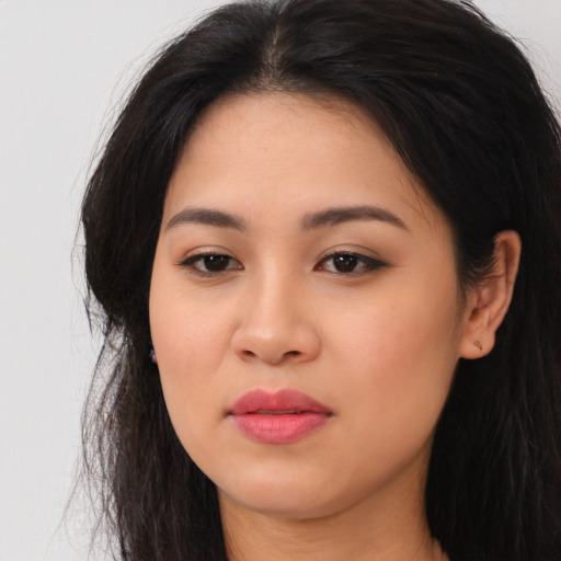 Joyful latino young-adult female with long  brown hair and brown eyes