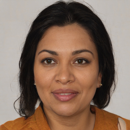 Joyful latino adult female with medium  brown hair and brown eyes