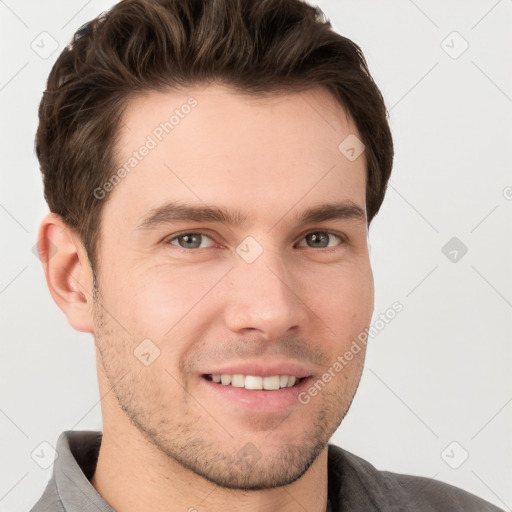 Joyful white young-adult male with short  brown hair and grey eyes