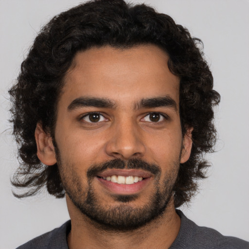 Joyful black young-adult male with short  brown hair and brown eyes