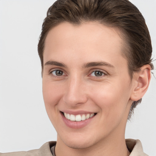 Joyful white young-adult female with short  brown hair and grey eyes