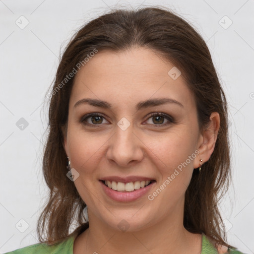 Joyful white young-adult female with medium  brown hair and green eyes