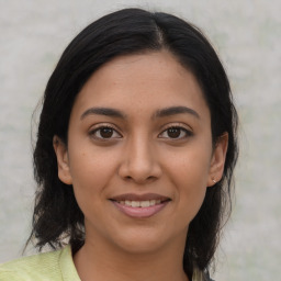 Joyful latino young-adult female with medium  brown hair and brown eyes