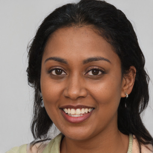 Joyful black young-adult female with medium  brown hair and brown eyes