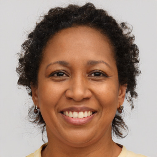 Joyful black adult female with medium  brown hair and brown eyes