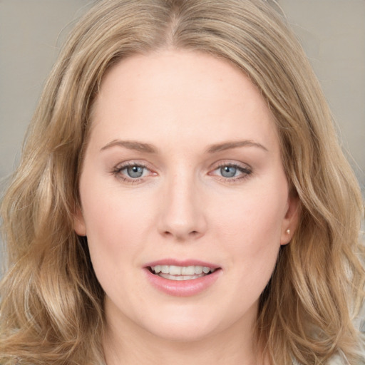 Joyful white young-adult female with long  brown hair and blue eyes