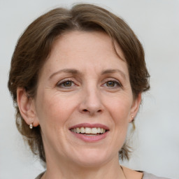 Joyful white adult female with medium  brown hair and grey eyes