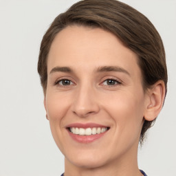 Joyful white young-adult female with short  brown hair and grey eyes