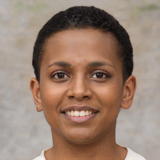 Joyful black young-adult female with short  black hair and brown eyes