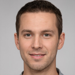 Joyful white young-adult male with short  brown hair and grey eyes