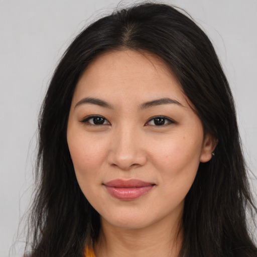 Joyful asian young-adult female with long  brown hair and brown eyes