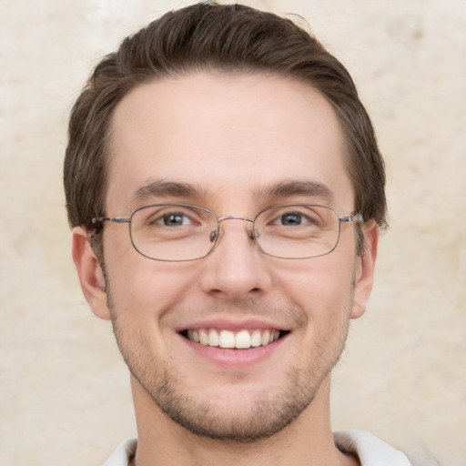 Joyful white young-adult male with short  brown hair and grey eyes