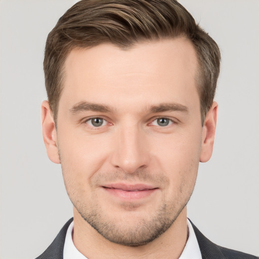 Joyful white young-adult male with short  brown hair and grey eyes