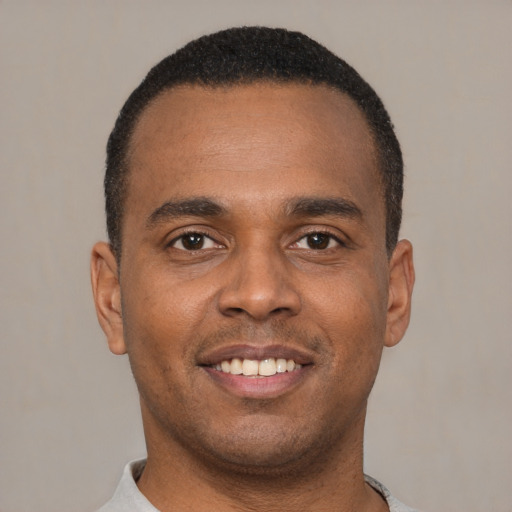 Joyful latino young-adult male with short  brown hair and brown eyes