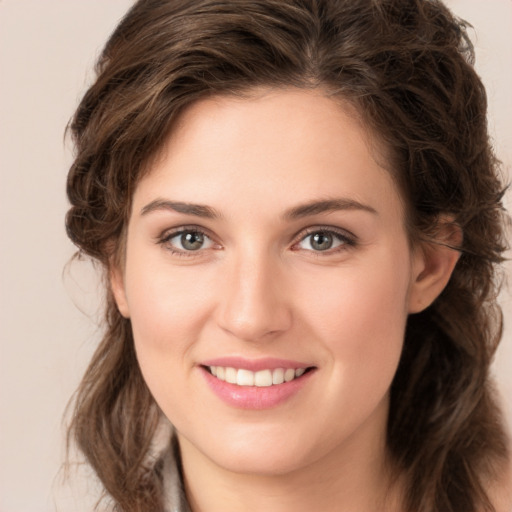 Joyful white young-adult female with long  brown hair and green eyes