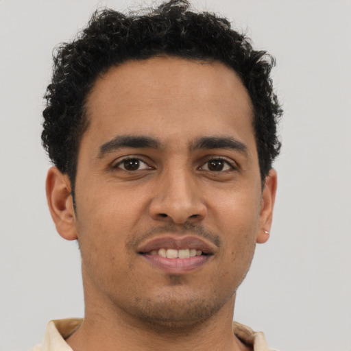 Joyful latino young-adult male with short  brown hair and brown eyes