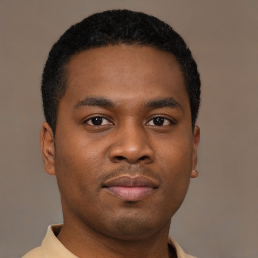 Joyful black young-adult male with short  brown hair and brown eyes