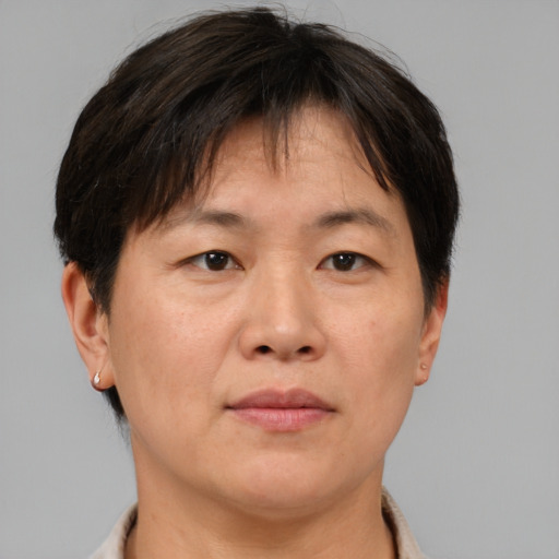 Joyful asian adult female with short  brown hair and brown eyes