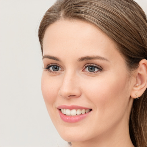 Joyful white young-adult female with long  brown hair and blue eyes