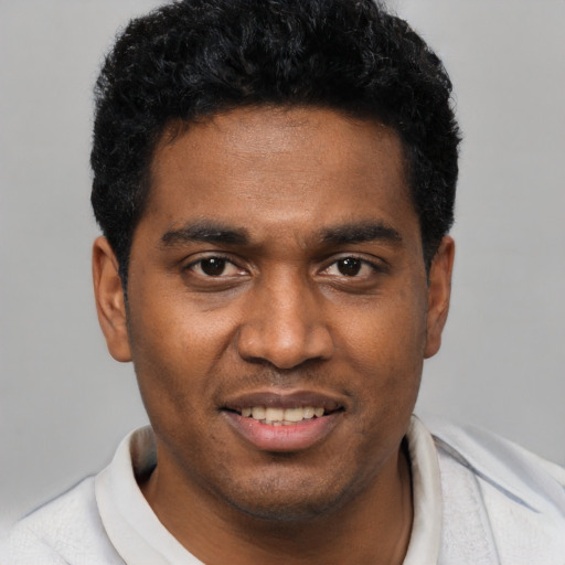 Joyful black young-adult male with short  black hair and brown eyes