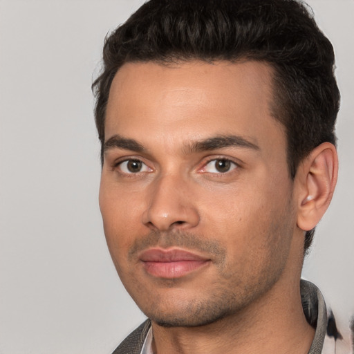 Joyful white young-adult male with short  black hair and brown eyes