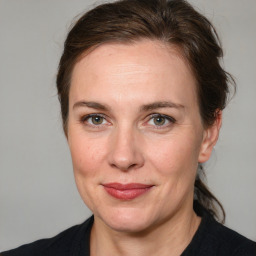 Joyful white adult female with medium  brown hair and grey eyes