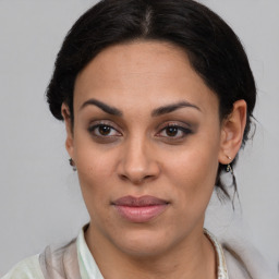 Joyful latino young-adult female with medium  brown hair and brown eyes