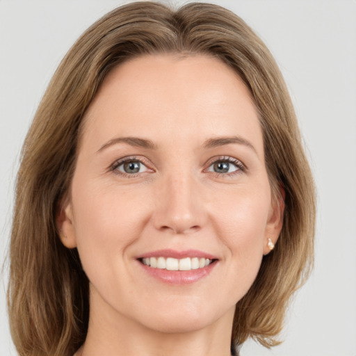 Joyful white young-adult female with medium  brown hair and green eyes