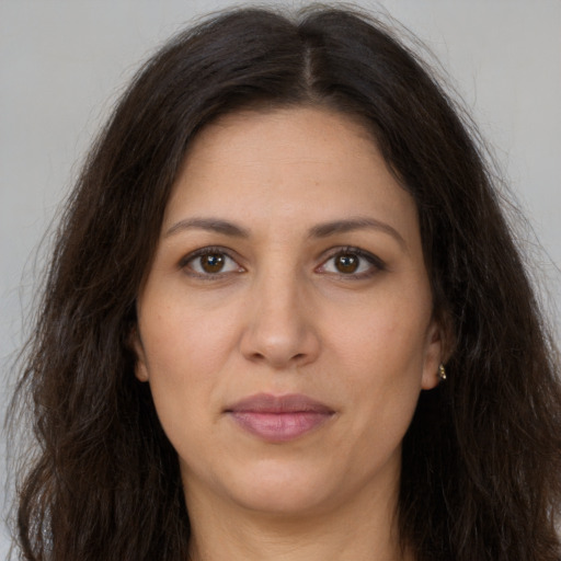 Joyful white adult female with long  brown hair and brown eyes