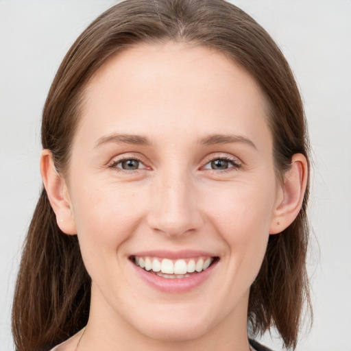 Joyful white young-adult female with medium  brown hair and blue eyes