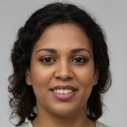 Joyful latino young-adult female with medium  brown hair and brown eyes