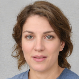 Joyful white young-adult female with medium  brown hair and blue eyes