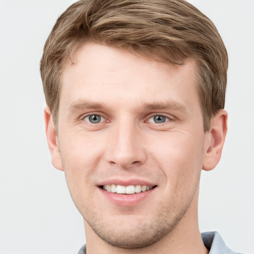 Joyful white young-adult male with short  brown hair and grey eyes