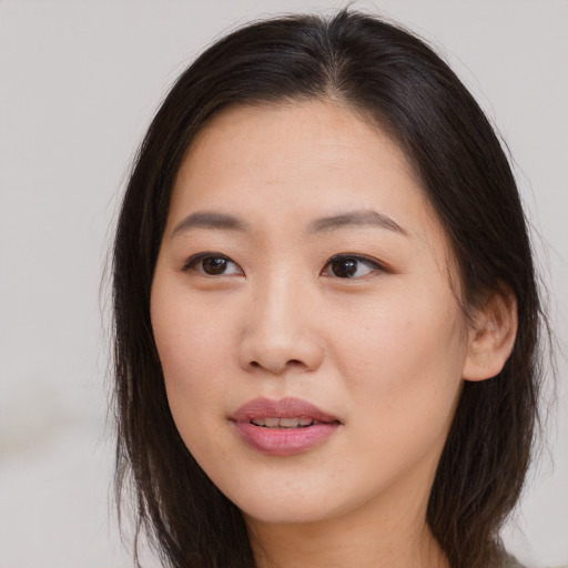 Joyful asian young-adult female with long  brown hair and brown eyes