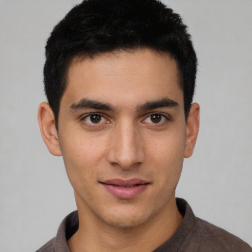 Joyful white young-adult male with short  black hair and brown eyes