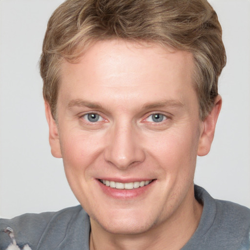 Joyful white adult male with short  brown hair and grey eyes