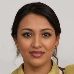 Joyful latino young-adult female with medium  brown hair and brown eyes