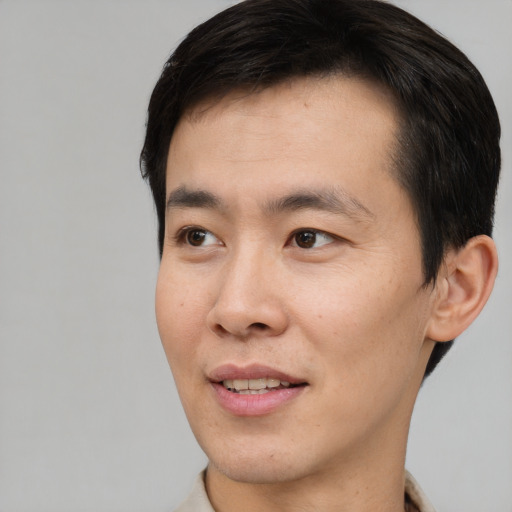 Joyful white young-adult male with short  black hair and brown eyes