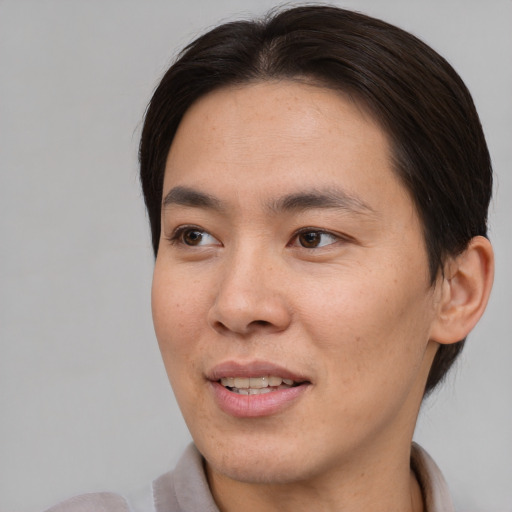 Joyful asian young-adult male with short  brown hair and brown eyes