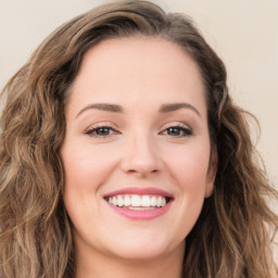 Joyful white young-adult female with long  brown hair and green eyes