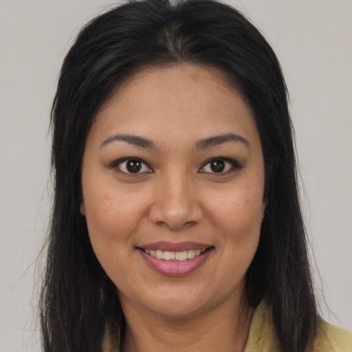 Joyful latino young-adult female with long  brown hair and brown eyes