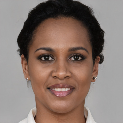 Joyful black young-adult female with short  brown hair and brown eyes