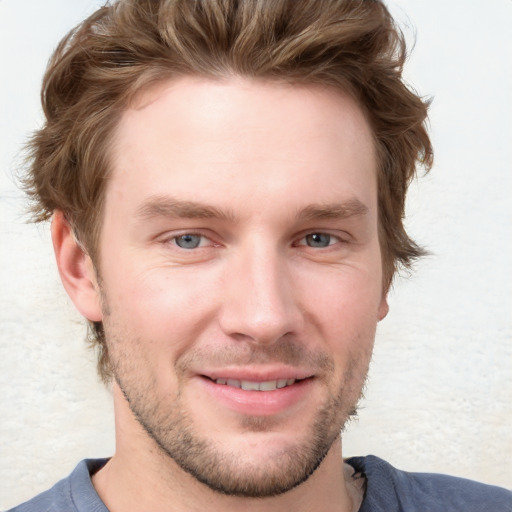 Joyful white young-adult male with short  brown hair and blue eyes