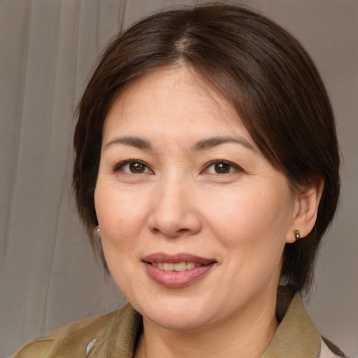 Joyful white adult female with medium  brown hair and brown eyes