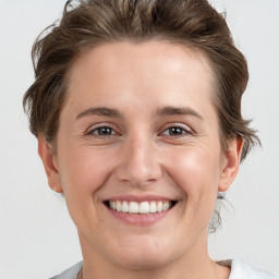 Joyful white young-adult female with short  brown hair and grey eyes