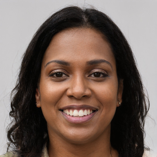 Joyful black young-adult female with long  brown hair and brown eyes